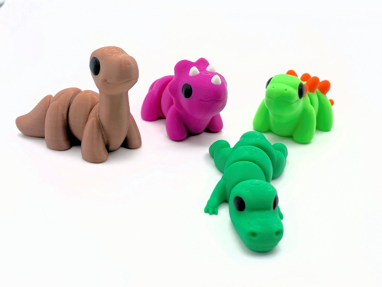 4 Dinosaur Pack featuring Cute Stegosaurus, Beautiful Triceratops, Silky Brontosaurus, and roaring spectacular Tyrannosaurs Rex